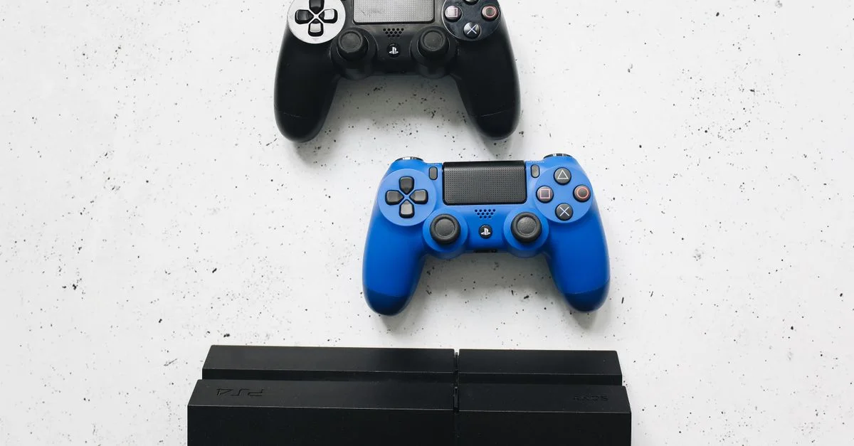 Deux manettes de jeu placées sur une surface blanche au-dessus d'une console de jeu.